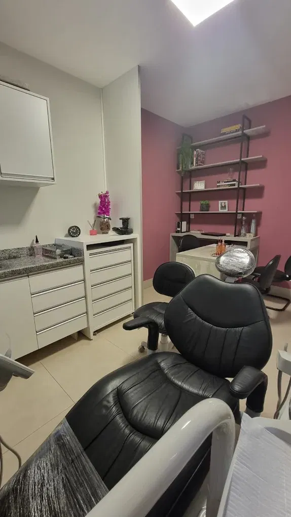 Consultório da Odontologia Faciale com parede rosé e cadeira odontológica